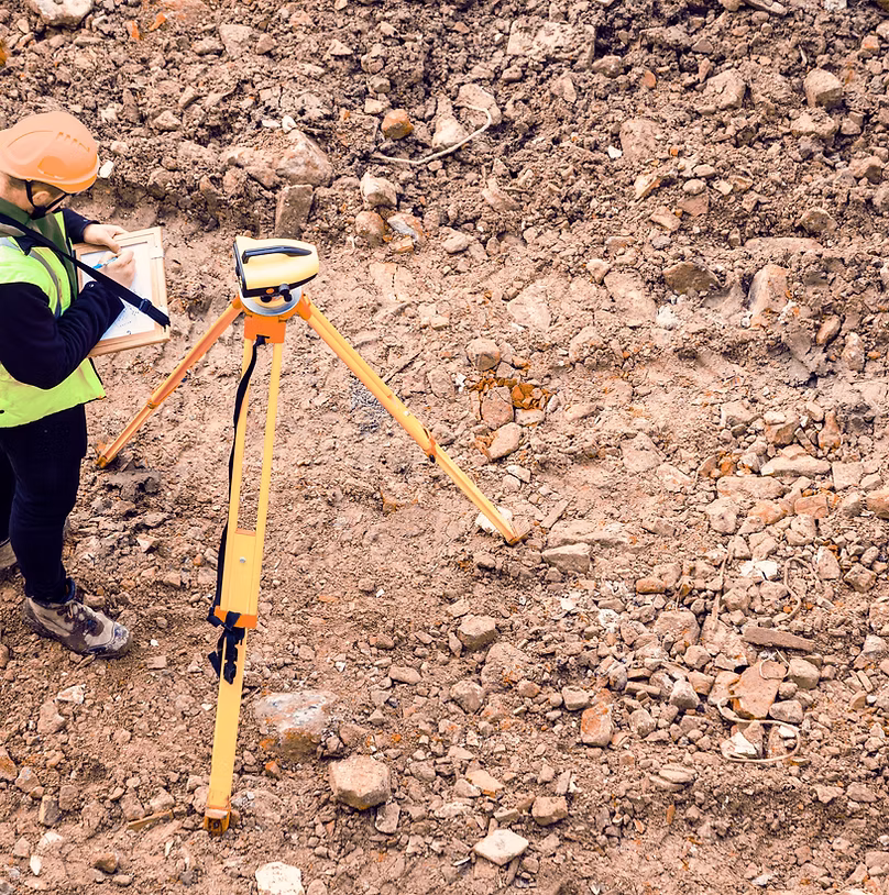 Field worker using surveying equipment.